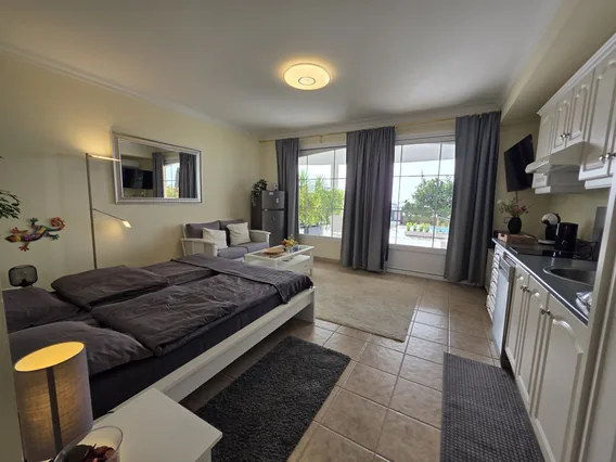 Bett und Sitzecke im offenen Raum der Wohnung Blanco