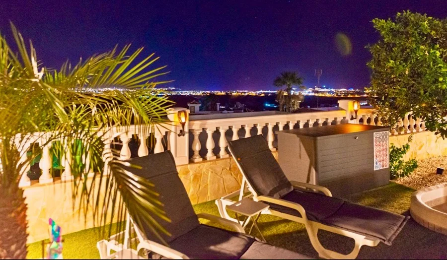 Sonnenliegen auf der beleuchteten Terrasse mit Blick auf die Lichter von Maspalomas